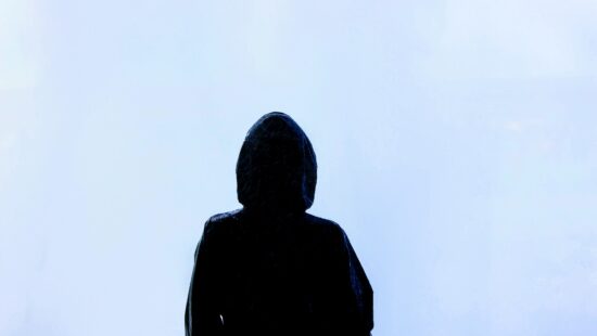 A silhouette of a person with a hooded jacket in a cloudy white background. For the RosaEmilia blog post No Desconozco.